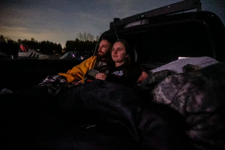 Sitting in the back of a pickup truck, Dustin Roberts and Ashlyn Rimsky from Walnutport watch "Leprechaun" at Shankweiler's Drive-In, near Allentown, in Orefield, Pa., on Friday, March 15, 2024. On April 13, the drive-in will celebrate its 90th anniversary.