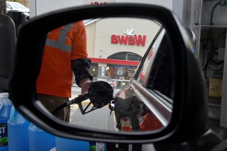 A driver's view in the rearview mirror as a full-service gas attendant fills the tank at the pump at a Wawa in Pennsauken, N.J April 2020.