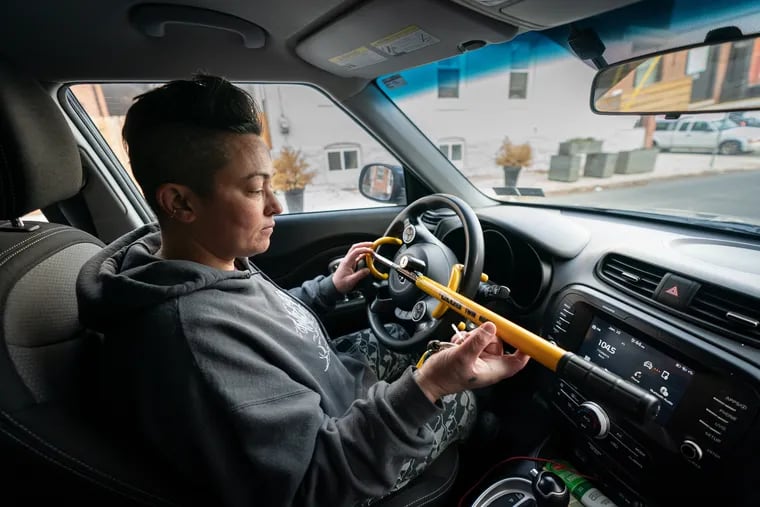 West Philly resident and former Kia owner Amy Nieves-Renz places a lock on her steering wheel after her car was stolen as part of the Kia Boyz Challenge at the end of 2022. Starting on March 27, the Philadelphia Police Department began giving out free steering wheel locks to turnkey Kia and Hyundai owners to help curb thefts.